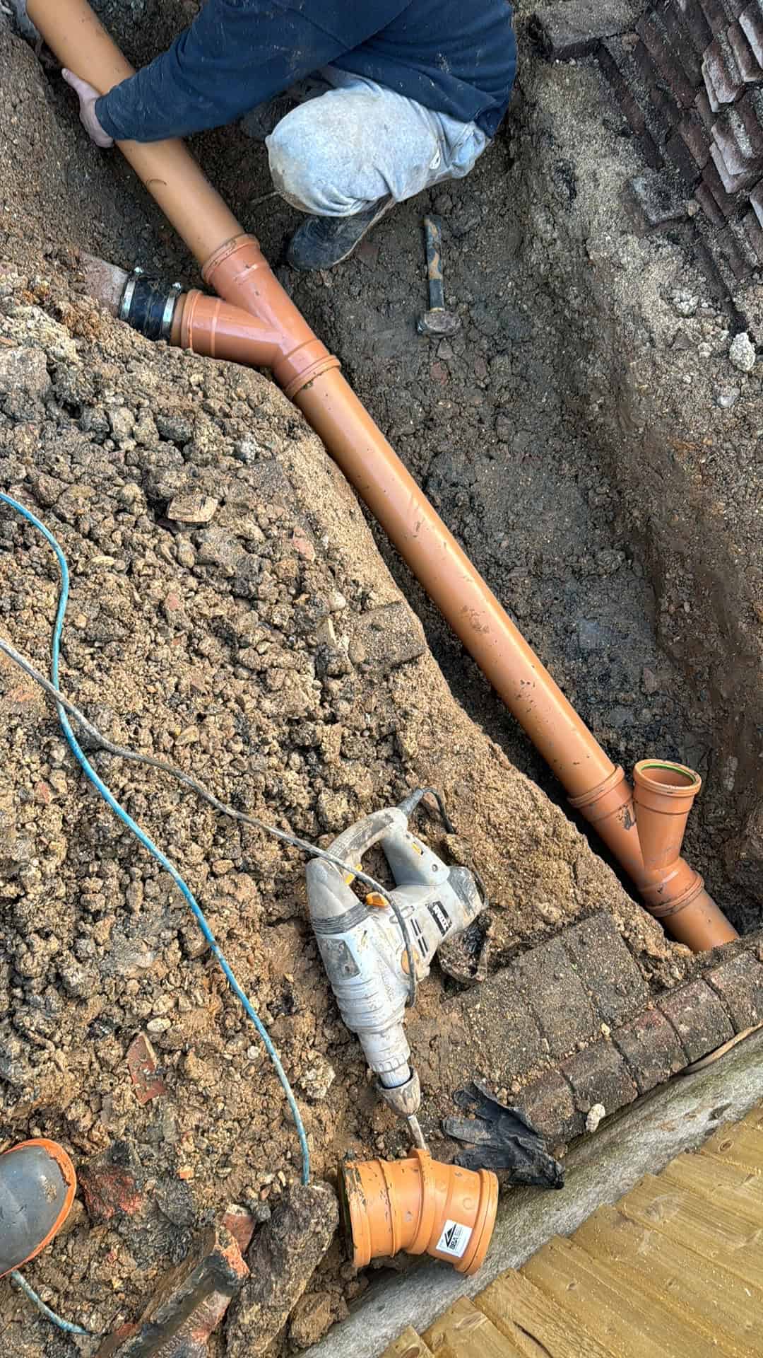 Installing a drainage pipe in a trench for effective water management. Best drain relining Reading service in berkshire