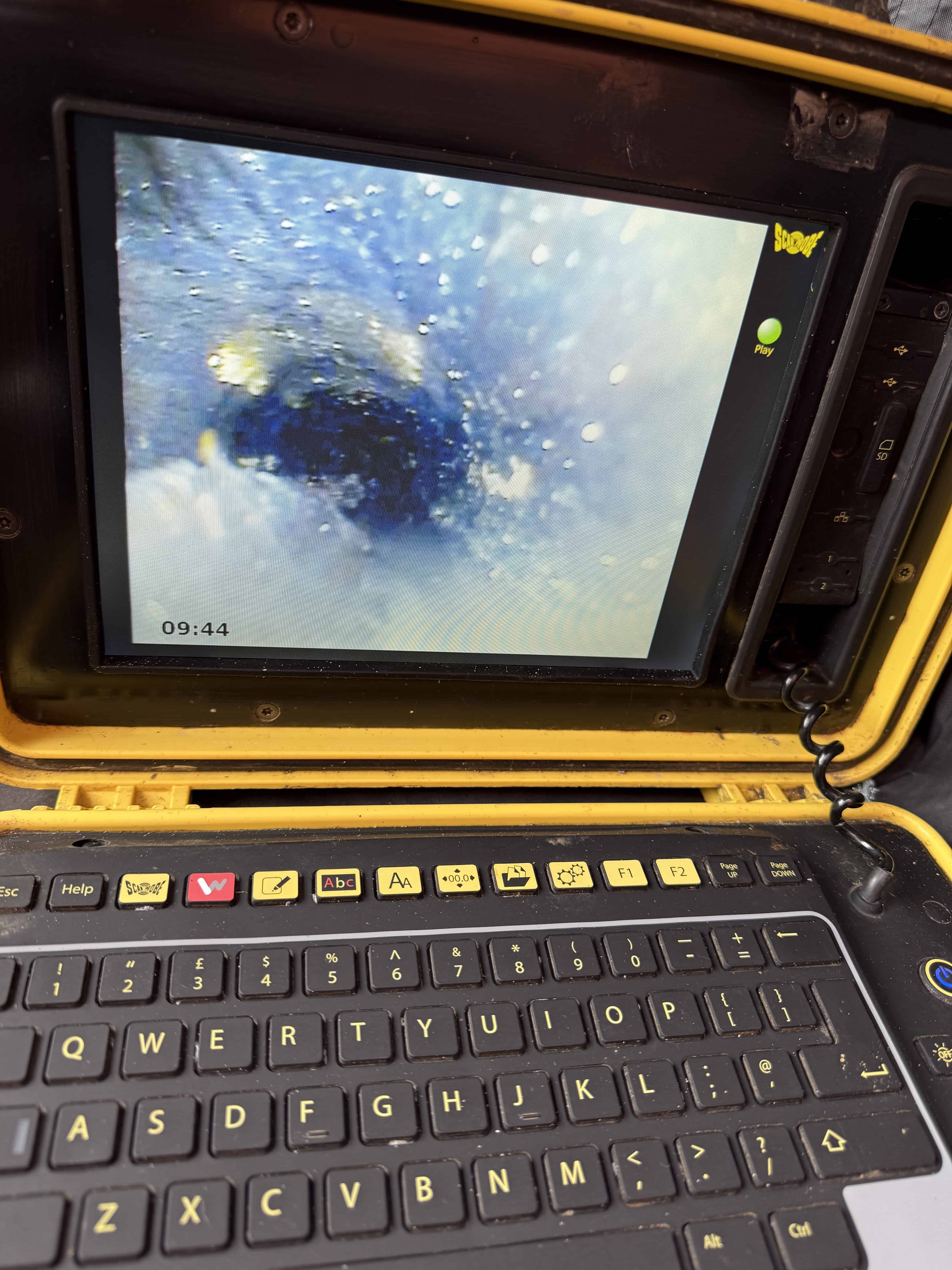 Inspection camera showing water flow inside a drain pipe.